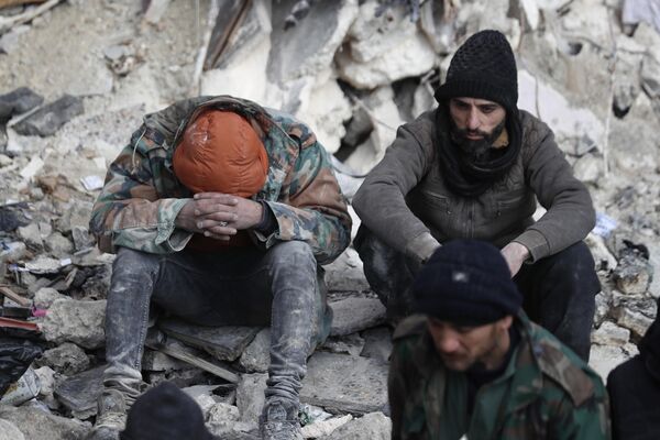 Люди на улице пострадавшего в результате землетрясения  сирийского города Алеппо