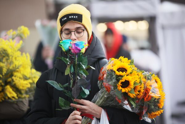 Молодой покупает цветы в преддверии Международного женского дня