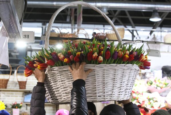 Мужчины несут корзину с цветами в преддверии Международного женского дня