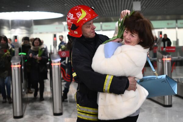 Сотрудник МЧС России поздравляет женщину с наступающим 8 марта