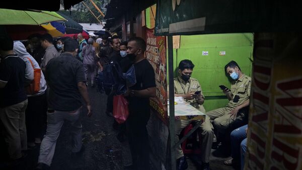 Мужчины ждут наступления времени приема пищи во время Рамадана в Джакарте  