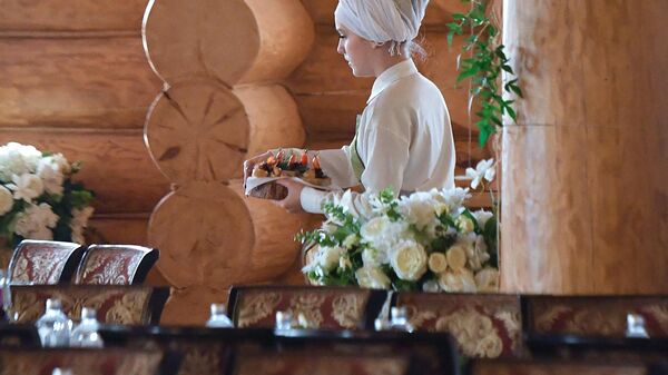 Официантка накрывает стол перед первым Ифтаром в Казани 