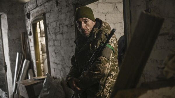 Украинский военнослужащий стоит в подвале убежища недалеко от Артемовска