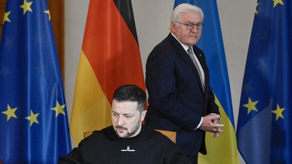 Президент Германии Франк-Вальтер Штайнмайер наблюдает, как президент Украины Владимир Зеленский подписывает гостевую книгу
