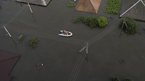 Люди в лодке на затопленной улице в Херсоне 