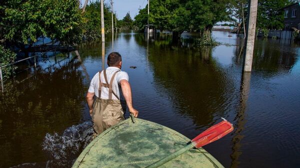 Мужчина ведет лодку по затопленным улицам Корсунки