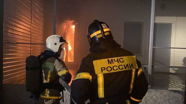 Спасатель во время тушения пожара на складе в Курской области
