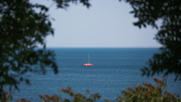 Яхта в акватории Черного моря неподалеку от пляжа в Анапе.