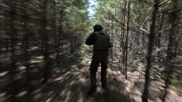 Военнослужащий ВС РФ ведет наступление в лесопосадке
