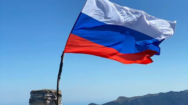 Крымские общественники водрузили на вершине в Крыму Флаг России с подписями бойцов СВО