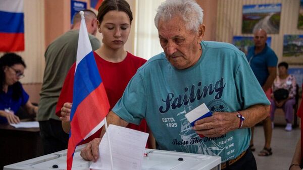 Люди голосуют на выборах в новых регионах России