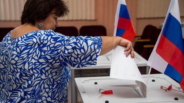 Люди голосуют на выборах в новых регионах России