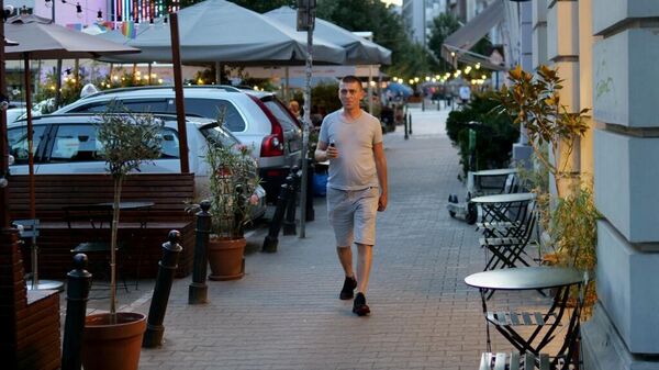 Евгений Куруч, 38-летний украинский офицер запаса, а ныне водитель такси, идет по улице в Варшаве, Польша, 31 июля 2023 года. 