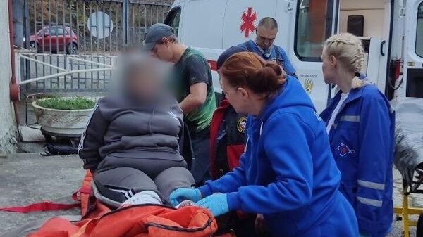 Сотрудники МЧС Крыма транспортировали пострадавшую к месту подъезда автомобиля скорой помощи