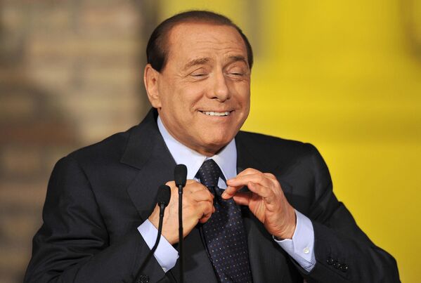 Премьер-министр Италии Сильвио Берлускони поправляет галстук во время пресс-конференции, Италия
