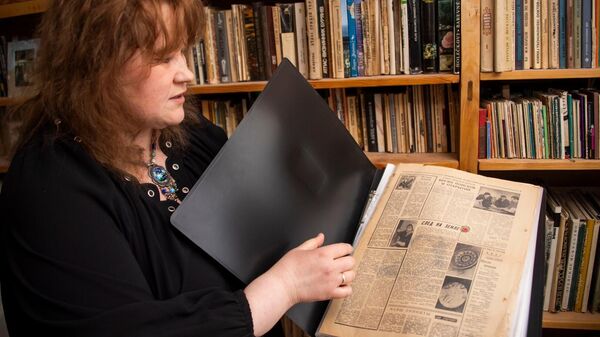 Людмила Королева-Корсун показывает архивные публикации о работе художественного комбинате, где трудились ее свекровь и свекор