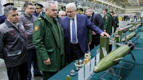 Министр обороны РФ Сергей Шойгу (второй слева) осматривает образцы высокоточных боеприпасов и зенитных управляемых ракет