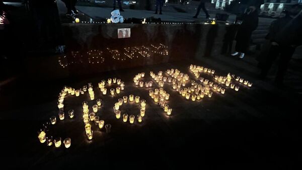 Крымчане несут цветы и зажигают свечи, выкладывая слова Москва, скорбим