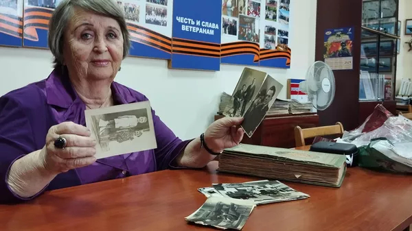 Лилия Яковлевна Тимошенко показывает фотографии военных лет из семейного архива