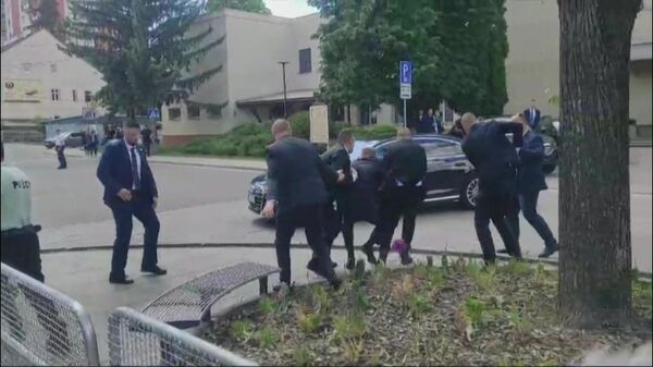 Сотрудники службы безопасности несут премьер-министра Словакии Роберта Фицо (в центре) к автомобилю после стрельбы