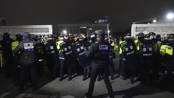 Полицейские стоят на страже перед зданием Национальной ассамблеи в Сеуле, Южная Корея, во вторник, 3 декабря 2024 г