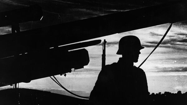 1 декабря 1939 года: черный силуэт немецкого солдата, стоящего перед своей позицией на фоне вечернего солнца. (Фото Topical Press Agency/Getty Images)
