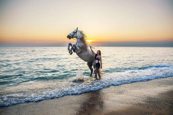 Инна Малышева с конем Блеском, исполняющим в море трюк Свеча.