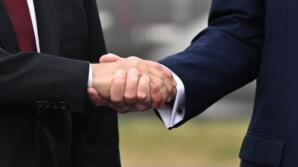 Президент РФ Владимир Путин и президент США Дональд Трамп пожимают руки во время встречи на военной базе Эльмендорф-Ричардсон на Аляске.