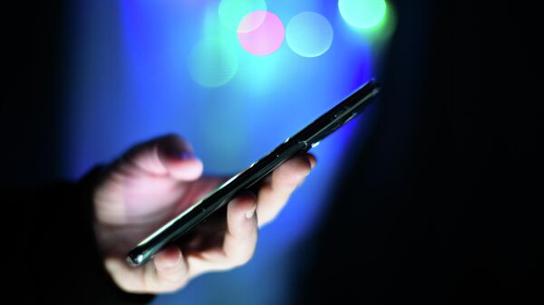 Мужчина держит в руках мобильный телефон