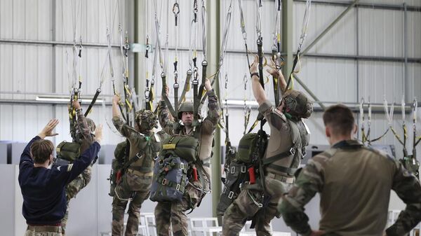 Британский десантник инструктирует французских десантников во время совместных британо-французских учений 