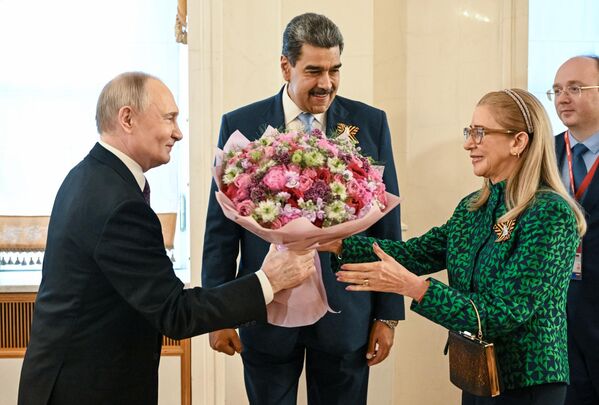 Президент РФ Владимир Путин вручает цветы супруге президента Венесуэлы Силии Флорес