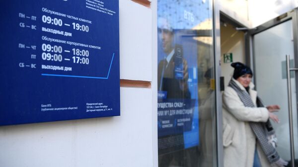 Женщины выходит из офиса ВТБ банка в Москве.