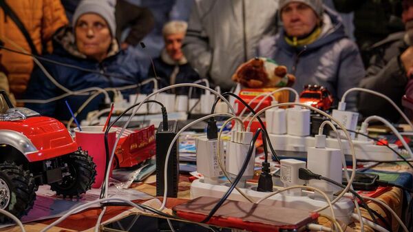 Люди заряжают свои телефоны в одной из обогреваемых палаток. Украина Люди заряжают свои телефоны в одной из обогреваемых палаток. Украина