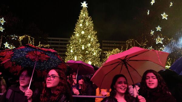 Люди слушают концерт во время дождя, а на площади Синтагма в Афинах, Греция Люди слушают концерт во время дождя, а на площади Синтагма в Афинах, Греция