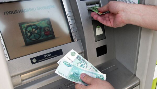 Снятие наличных денег через банкомат. Архивное фото