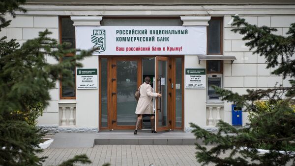 Женщина входит в здание Российского национального коммерческого банка в городе Севастополе