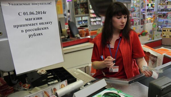 Кассирша одного из магазинов Симферополя принимает российские рубли к оплате за покупку, 2 июня 2014