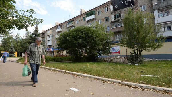Мужчина идет возле поврежденного жилого дома в Горловке. Архивное фото