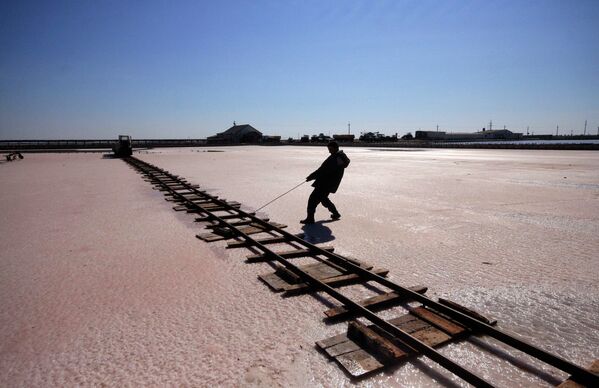 Рабочий кладет рельсы по дну соляного озера Сасык-Сиваш