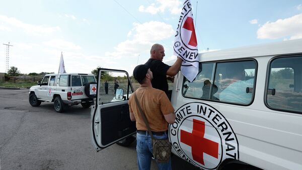 Сотрудники Международного Красного Креста, которые сопровождают колонну автомобилей КамАЗ с гуманитарной помощью для жителей юго-востока Украины, на КПП Донецк