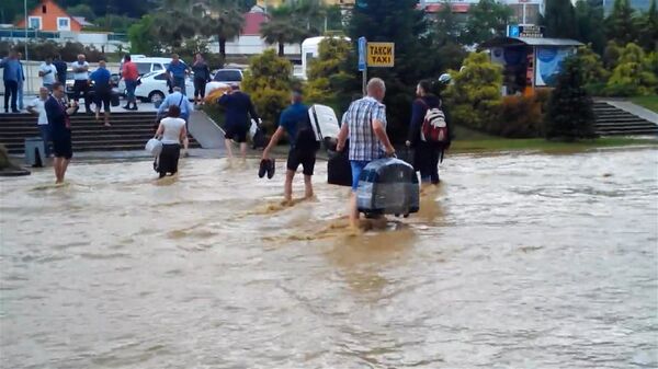 Пассажиры по колено в воде несли багаж из затопленного аэропорта Сочи Пассажиры по колено в воде несли багаж из затопленного аэропорта Сочи
