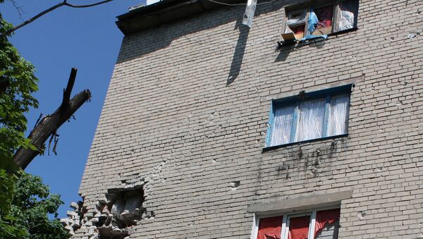 Окна без стекол в пострадавших от обстрелов жилых домах в Донецке