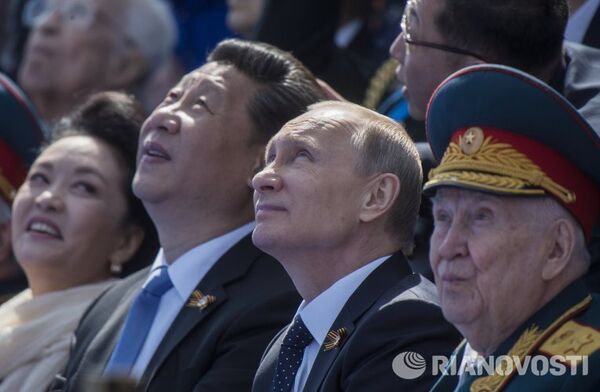 Владимир Путин и председатель Китайской Народной Республики Си Цзиньпин с супругой Пэн Лиюань во время военного парада в ознаменование 70-летия Победы в Великой Отечественной войне 1941-1945 годов, 9 мая 2015 года.
