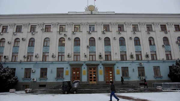 Машина убирает снег на входе в здание Совета министров Крыма