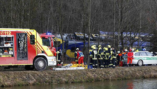 Сотрудники службы спасения на месте столкновения двух пассажирских поездов в Германии. 9 февраля 2016