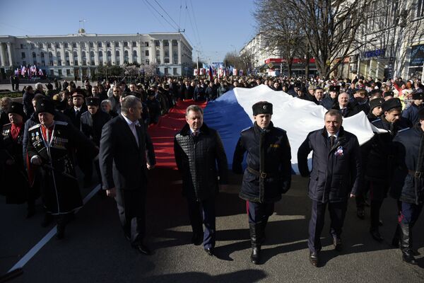 Торжественные мероприятия в Симферополе в честь второй годовщины референдума 2014 года. Начало шествия. Глава РК Сергей Аксенов, полпред президента в КФО Олег Белавенцев и председатель Госсовета РК Владимир Константинов несут российский флаг