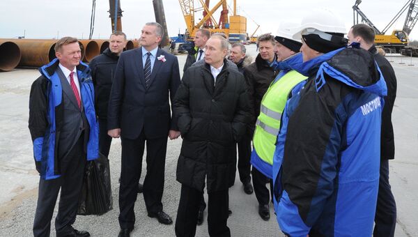 Президент России Владимир Путин (в центре) во время посещения строительной площадки транспортного перехода через Керченский пролив на острове Тузла