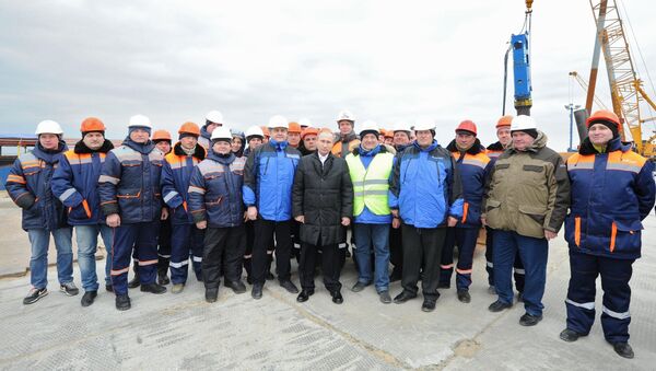 Президент России Владимир Путин (в центре) с рабочими во время посещения строительной площадки транспортного перехода через Керченский пролив на острове Тузла