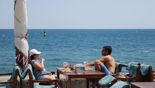 Отдыхающие в кафе на пляже в Ялте