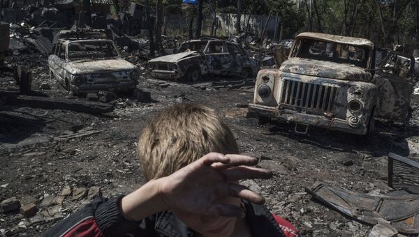 Автомобили, сгоревшие в результате обстрела украинскими силовиками, в поселке Лозовое города Донецка. Июль 2016 года.